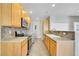 Functional kitchen equipped with stainless steel appliances, wooden cabinetry, and tile backsplash at 14333 E Napa Pl # 5D, Aurora, CO 80014