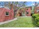 Spacious backyard featuring a well-maintained lawn, partial fence, and brick feature with a Juliet balcony at 1545 Steele St, Denver, CO 80206