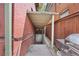 Exterior view of a covered basement entrance, next to the BBQ on the side of a red brick house at 1545 Steele St, Denver, CO 80206