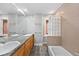 Bright bathroom with dual sinks, granite counters, tub and unique glass block shower at 1545 Steele St, Denver, CO 80206