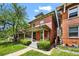 Charming two-story brick home with a covered front porch, manicured lawn, and mature landscaping at 1545 Steele St, Denver, CO 80206