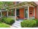 Inviting front porch with brick facade, gray painted steps, and mature landscaping at 1545 Steele St, Denver, CO 80206