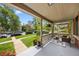 Spacious covered front porch overlooking a lush, green lawn with treelined streets at 1545 Steele St, Denver, CO 80206