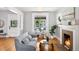 Bright living room features hardwood floors, a cozy fireplace, and large windows at 1545 Steele St, Denver, CO 80206