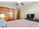 Cozy bedroom featuring a ceiling fan, television, and closet with wooden doors at 2957 W Rowland Ave, Littleton, CO 80120