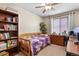 Cozy bedroom with a ceiling fan, natural light, and a built-in bookshelf perfect for a relaxing retreat at 2957 W Rowland Ave, Littleton, CO 80120