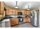 Kitchen with wood cabinets, stainless steel appliances, and wood flooring at 2957 W Rowland Ave, Littleton, CO 80120