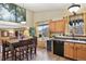 Eat-in kitchen with wood cabinets, black appliances, and wine storage at 2957 W Rowland Ave, Littleton, CO 80120