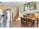 Bright kitchen and dining area with stainless steel appliances, wood cabinetry, and staircase access at 2957 W Rowland Ave, Littleton, CO 80120