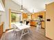 Bright kitchen featuring stainless steel appliances, wooden cabinets, and a dining area with a large window at 2957 W Rowland Ave, Littleton, CO 80120