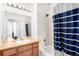 Bathroom with tub, shower, and navy striped curtain at 6723 S Winnipeg Cir # 104, Aurora, CO 80016