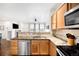 Galley-style kitchen with granite countertops, stainless steel appliances, and wood cabinets at 6723 S Winnipeg Cir # 104, Aurora, CO 80016