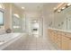 Bright bathroom featuring tile floors, bathtub, glass-enclosed shower, and a double sink at 228 Emerald Ct, Castle Rock, CO 80104