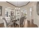 Well-lit dining room with a glass table, patterned chairs, hardwood floors, and elegant chandelier at 228 Emerald Ct, Castle Rock, CO 80104