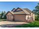 Charming home with a three-car garage, complemented by a well-manicured lawn and mature landscaping at 228 Emerald Ct, Castle Rock, CO 80104