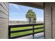 Balcony view showing a lush green lawn, a large tree, and neighborhood homes in the distance at 579 Wright St # 204, Lakewood, CO 80228