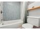This bathroom features a shower-tub combination with white fixtures, and blue accent tiling on the wall at 579 Wright St # 204, Lakewood, CO 80228