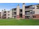 Multi-level condo building with balconies and a well-maintained lawn at 579 Wright St # 204, Lakewood, CO 80228