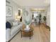 Bright living room featuring wood floors, a comfortable sofa, and an open dining area at 579 Wright St # 204, Lakewood, CO 80228