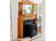 Close-up of a vintage wooden fireplace mantel with an ornate design and modern gas insert at 3110 N Franklin St, Denver, CO 80205