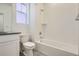 Bright bathroom featuring a shower over tub, white tile surround, and a natural light filled window at 917 W Beverly St, Elizabeth, CO 80107