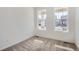A clean bedroom featuring carpet flooring and natural light streaming in from two windows at 917 W Beverly St, Elizabeth, CO 80107