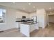 Modern kitchen with stainless steel appliances, white cabinetry, an island, and hardwood floors at 917 W Beverly St, Elizabeth, CO 80107