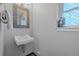 Charming powder room featuring a gray vanity, window, and tiled floors at 1153 S Biscay St, Aurora, CO 80017