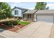 Charming home with brick accents, landscaped front yard, and a two-car garage with a paved driveway at 1153 S Biscay St, Aurora, CO 80017