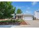 Charming home with brick accents, landscaped front yard, and a two-car garage with a paved driveway at 1153 S Biscay St, Aurora, CO 80017