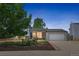 Charming home at dusk with brick accents, landscaped front yard, and a two-car garage with a paved driveway at 1153 S Biscay St, Aurora, CO 80017