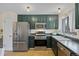 Well-lit kitchen with stainless steel appliances and plenty of green cabinet space at 1153 S Biscay St, Aurora, CO 80017