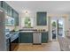 Eat-in kitchen with green cabinets, stainless appliances, and outdoor patio access at 1153 S Biscay St, Aurora, CO 80017
