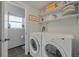 Bright laundry room with white washer and dryer, shelving, and decorative laundry sign at 1153 S Biscay St, Aurora, CO 80017