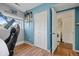 Bedroom featuring a laundry room with a washing machine, blue walls, and wood floors at 1153 S Biscay St, Aurora, CO 80017