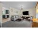 Spacious living room with a comfortable gray sofa, TV and a view into the adjacent kitchen at 1153 S Biscay St, Aurora, CO 80017