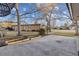 Spacious backyard with a concrete patio area, mature trees, and landscaping at 21 Birdie Ln, Littleton, CO 80123