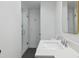 Modern bathroom with sleek glass-enclosed shower, white vanity, and dark tile flooring at 21 Birdie Ln, Littleton, CO 80123