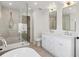 Spa-like bathroom featuring dual sinks, a soaking tub with a shower, and modern fixtures at 21 Birdie Ln, Littleton, CO 80123