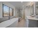 Modern bathroom with a soaking tub, glass-enclosed shower, and dual sinks at 21 Birdie Ln, Littleton, CO 80123