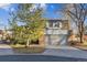 Charming two-story home featuring a brick facade and an attached two-car garage with landscaped yard and mature trees at 21 Birdie Ln, Littleton, CO 80123