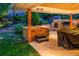 Backyard retreat with a hot tub, stone patio, outdoor grill, and lush landscaping at 250 S Dahlia St, Denver, CO 80246