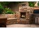 Outdoor fireplace and grill area in a landscaped backyard with stone patio at 250 S Dahlia St, Denver, CO 80246