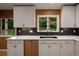 Bright kitchen with stainless steel dishwasher, white cabinets, and backyard views at 250 S Dahlia St, Denver, CO 80246