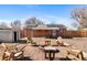 A backyard with a brick patio, fire pit, seating, solar panels, and minimal landscaping at 2738 Xanadu St, Aurora, CO 80011