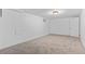 A bright basement space with carpeted floor, white walls, and a light fixture in the ceiling at 2738 Xanadu St, Aurora, CO 80011