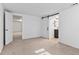 Spacious carpeted bedroom with a barn door leading to the renovated ensuite bathroom at 2738 Xanadu St, Aurora, CO 80011