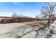 Side view of a brick home featuring a concrete driveway and partially fenced yard at 2738 Xanadu St, Aurora, CO 80011