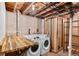 Unfinished basement laundry room area with new washer and dryer hookups at 2738 Xanadu St, Aurora, CO 80011