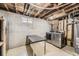 Unfinished basement includes a table and modern washer and dryer at 8258 Cherokee St, Denver, CO 80221
